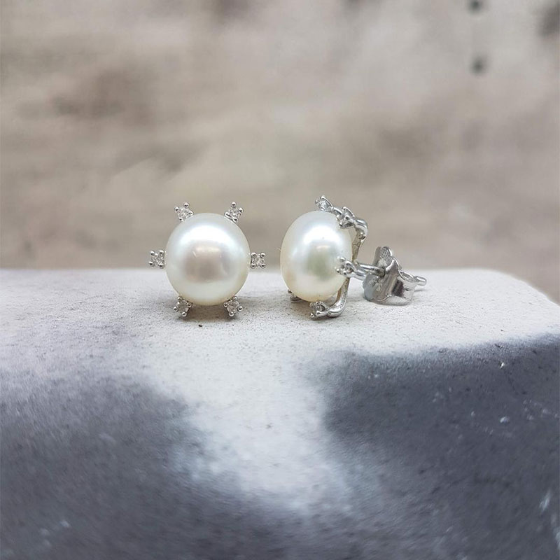 Womens white gold earrings K14 decorated with natural white pearls and white zircons.