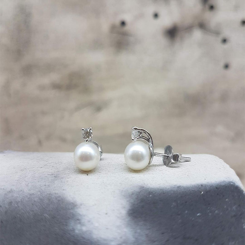 Womens white gold earrings K14 decorated with natural white pearls and white zircons.